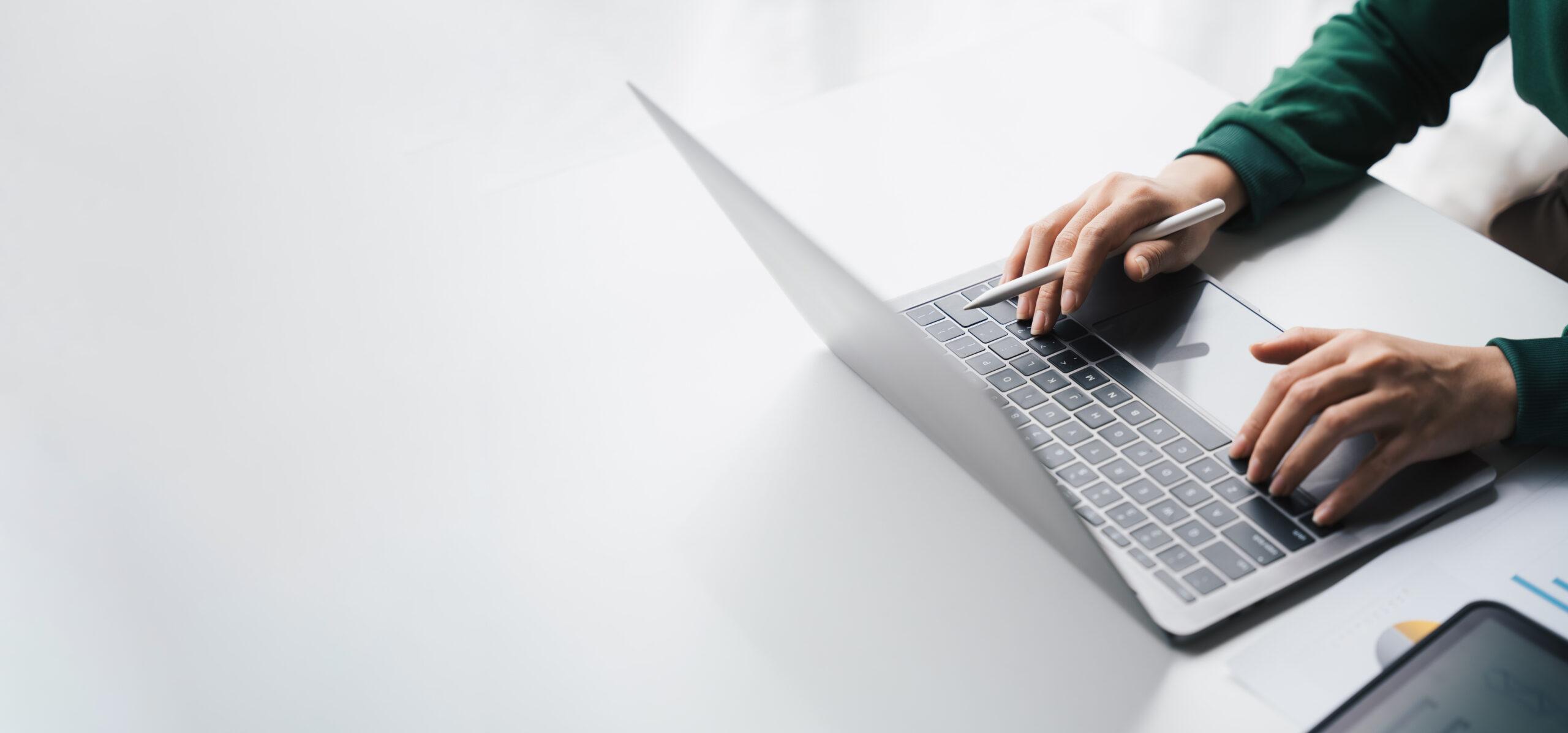 Guide to understandIng schema markup for SEO Man on his laptop at a white desk.